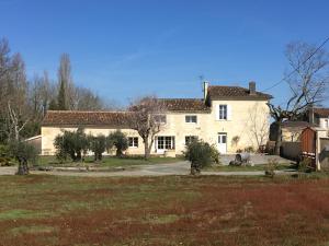 a large white house with trees in front of it at La Gelette in Génissac