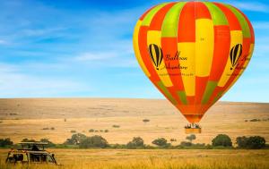 een heteluchtballon die over een veld vliegt bij Muthu Keekorok Lodge, Maasai Mara, Narok in Keekorok