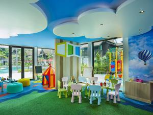 a childrens room with tables and chairs and a play area at Amari Koh Samui in Chaweng