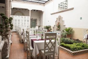 uma sala de jantar com mesas e cadeiras brancas em Casa Jose Maria em Morelia