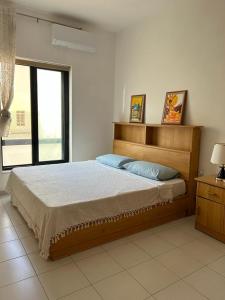 ein Schlafzimmer mit einem Bett und einem großen Fenster in der Unterkunft Galileo Rooms in Il- Gżira