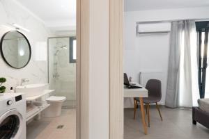 a white bathroom with a sink and a washing machine at PROPAN CITY SUITES in Volos +78 photos