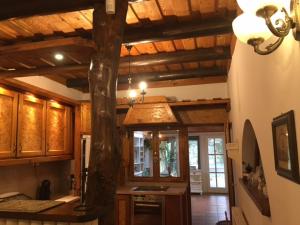 a kitchen with a wooden ceiling with a tree in it at SÓSTÓI UDVARHÁZ in Nyíregyháza