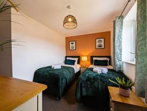 a hotel room with two beds and a table at 6 Guests * 4 Bedroom * Free Wi-Fi in Burton Latimer