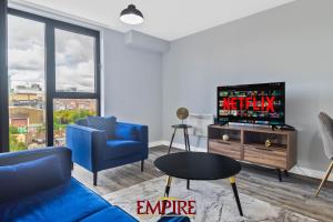 uma sala de estar com um sofá azul e uma televisão em 1 Bedroom Apartments in Digbeth em Birmingham