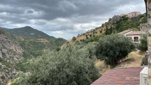 vistas a una montaña con árboles y a un edificio en L'oasi del raganello, en Civita