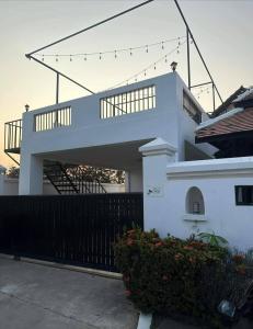 a white house with a staircase and a fence at Pattaya 6 bedroom pool villa in Jomtien Beach