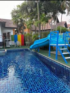 a blue slide in the middle of a swimming pool at Pattaya 6 bedroom pool villa in Jomtien Beach