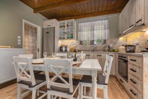 a kitchen with a white table and chairs at Chalet Perivoli 