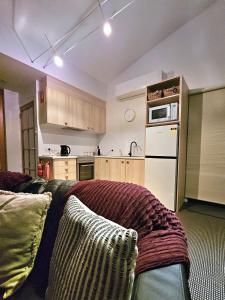 Cloud Nine Apartment @ Tamar Ridge في Grindelwald: مطبخ مع سرير وفرن مايكرويف