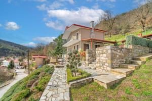 a house on a hill with a stone path leading to it at Chalet Perivoli 