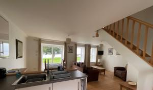 a kitchen and living room with a sink and a staircase at Primrose Cottage in Killean