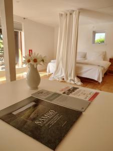 a magazine on a counter in a room with a bedroom at Købmandsgården in Ballen