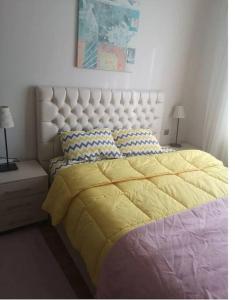 a bedroom with a large bed with a yellow blanket at Eltes Gold Residance in Umraniye