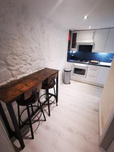 uma cozinha com uma mesa de madeira num quarto em 2-level apartment em Aberdeen