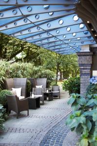 a patio with chairs and tables under a blue canopy at Boston Apartments HH in Hamburg