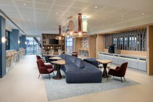 een lobby met een bank, tafels en een bar bij Hampton By Hilton Rochdale in Rochdale