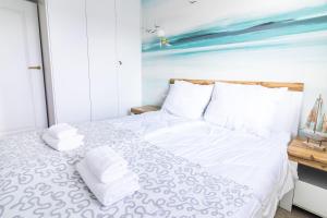 - une chambre avec un lit blanc et des serviettes dans l'établissement Może morze, à Kołobrzeg