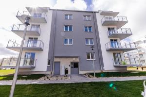 un grand bâtiment blanc avec balcon et lumière de rue dans l'établissement Może morze, à Kołobrzeg