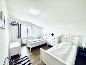 a white bedroom with a bed and a dresser at Monteurzimmer ZIMMERzuVERMIETEN in Deitingen Neumatt in Deitingen