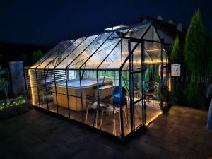 a glass greenhouse with a table and chairs in it at Apartamenty pod Gromadzyniem in Ustrzyki Dolne