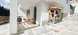 a patio with a table and chairs on a house at Mountain Pearls Home 9 in Vodata