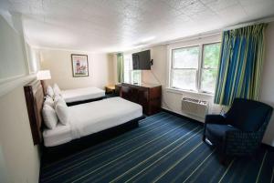 um quarto de hotel com uma cama e uma cadeira em Days Inn by Wyndham Bar Harbor em Bar Harbor