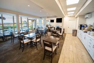 cocina y comedor con mesas y sillas en Days Inn by Wyndham Bar Harbor, en Bar Harbor