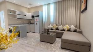 a living room with a couch and a kitchen at Emaar Holiday Homes Business Gate Al Murouj - A in Riyadh