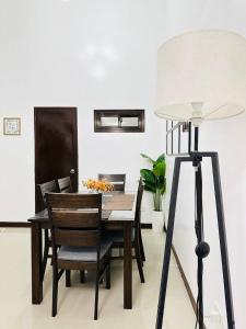 een tafel en stoelen en een lamp in een kamer bij Casa Mercado lV in Lipa