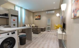 a laundry room with a washer and a living room at Emaar Holiday Homes Business Gate Al Murouj - A in Riyadh