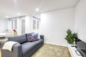 Una sala de estar con un sofá gris y una mesa. en Cosy flat, Braga city center, en Braga