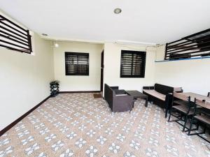 an empty room with chairs and tables and windows at Casa Mercado lV in Lipa