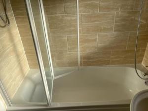 y baño con ducha y puerta de cristal. en 3 bedroom mid terraced house (2 double & 1 single), en Grays