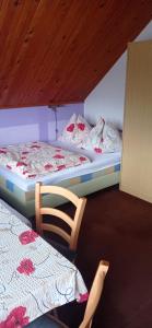 Habitación con 2 camas, silla y mesa. en Penzion Iva en Tanvald