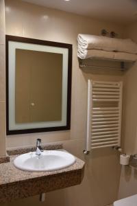 a bathroom with a sink and a mirror and towels at Hotel SNO Edelweiss in Cerler