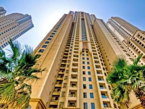 a tall building with palm trees in front of it at Dubai Eye in Dubai