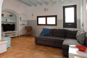 uma sala de estar com um sofá e uma televisão em Lets Holidays COZY HOUSE in the CENTER of TOWN em Tossa de Mar