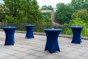 een groep blauwe tafels op een patio bij Hilton Alexandria Mark Center in Alexandria