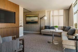 a living room with a couch and a tv at Hyatt Regency Houston Galleria in Houston