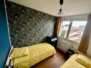 - une chambre avec un lit et un mur fleuri dans l'établissement Centre ville Dijon Wilson *Chez Charles* 2Ch, à Dijon
