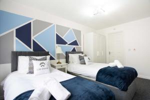 two beds in a room with blue and white at 30 Percent Off Monthly Stays - Free Parking - Sky & Netflix in Borehamwood