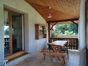 a wooden table and chairs on the porch of a house at Siedlisko pod Orzechem in Przyłęk