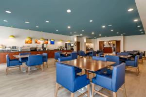 un comedor con sillas y mesas azules en Comfort Suites Conference Center Rapid City, en Rapid City