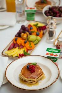 a plate of pancakes and a tray of fruit at Radisson Hotel Astana in Astana