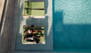 een uitzicht van twee personen in een zwembad bij Paralos Venus Suites Adults Only in Chersonissos