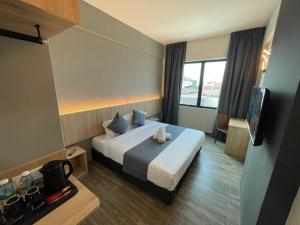 クアラ・トレンガヌにあるDJ Citi Plaza Hotel & Suitesのベッドとテレビが備わるホテルルームです。