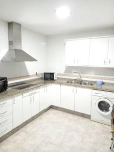 a white kitchen with a sink and a microwave at Centro de Sanlúcar, La Plata 23 in Sanlúcar de Barrameda
