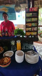 a man standing behind a table with plates of food at Highland Bungalows in Nungwi