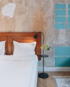 a bed with white pillows and a lamp in a room at Story Hotel Riddargatan, part of JdV by Hyatt in Stockholm